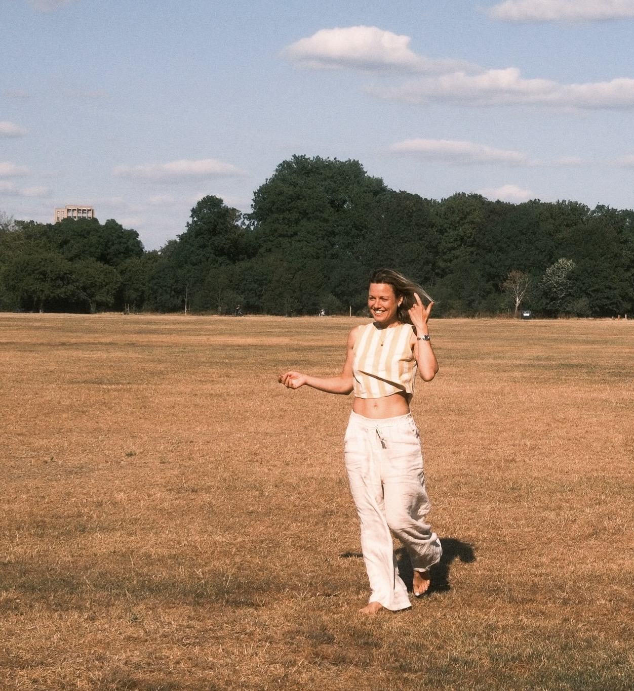 Jo dancing barefoot in a sunlit field
