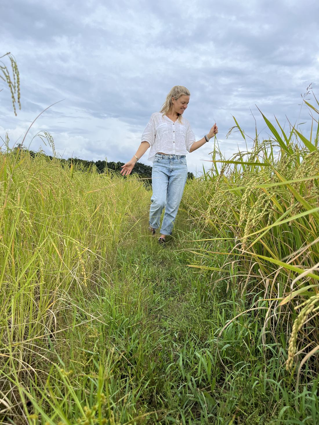 Jo walking along a path through tall grasses