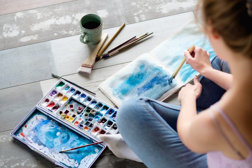 A woman painting with watercolours, her phone nowhere in sight